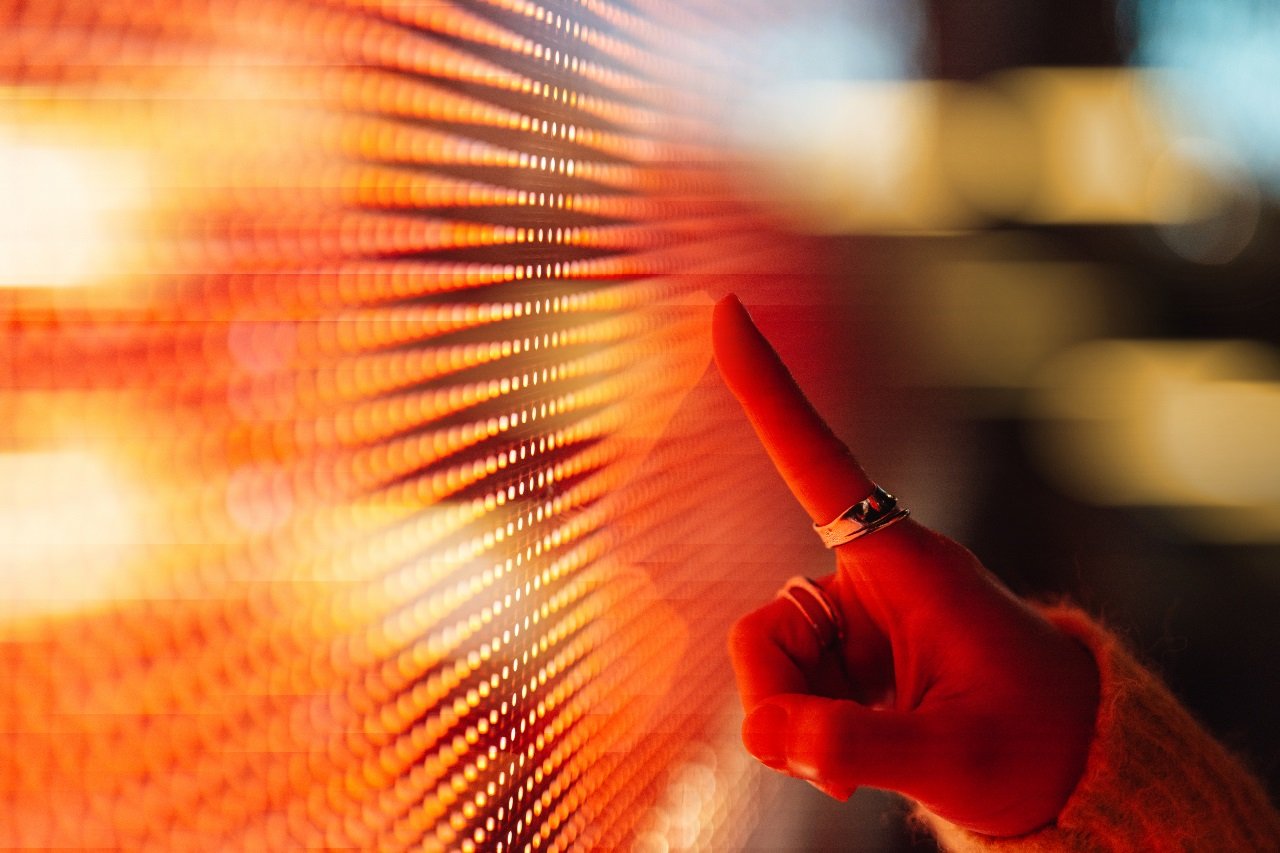 A person pointing at a light screen