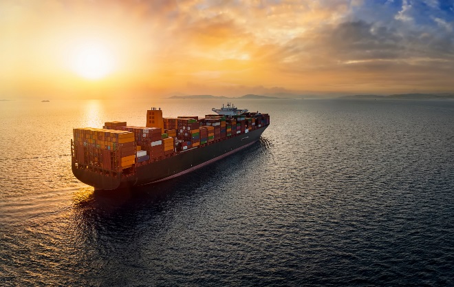 A commercial marine vehicle traveling on the sea at the sunset